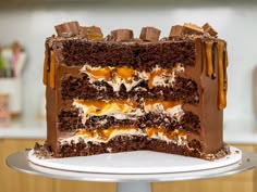 a chocolate cake with caramel drizzles and frosting on a white plate