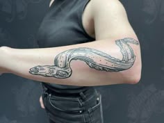 a woman with a snake tattoo on her arm