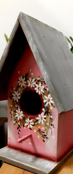 a bird house with flowers painted on it