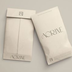 two envelopes sitting next to each other on top of a white surface with the word acrine printed on them