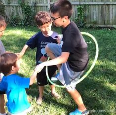 four young boys playing with a hula hoop