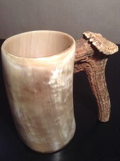 a wooden object sitting next to a ceramic cup