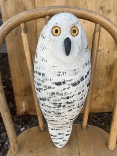 an owl statue sitting on top of a wooden chair