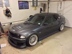 a grey car parked in a garage next to a wall