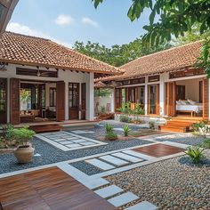 an outdoor area with wooden floors and white walls, surrounded by greenery and rocks