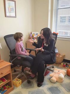 a woman sitting in a chair next to a child