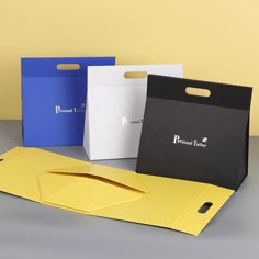 three different colored paper bags sitting next to each other