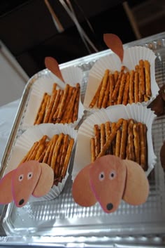 some paper plates filled with crackers shaped like dogs and carrots on top of them