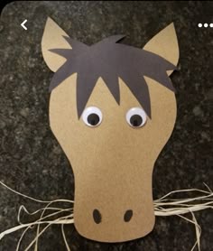 a paper horse head with eyes on it