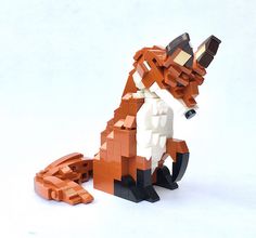an orange and white lego dog sitting on the ground