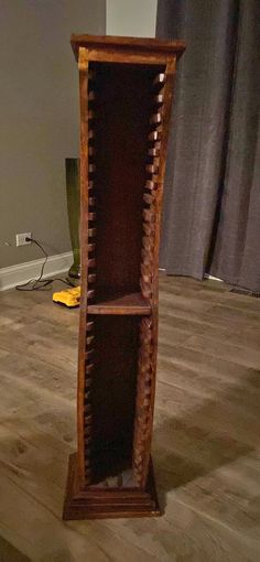 a tall wooden shelf sitting on top of a hard wood floor