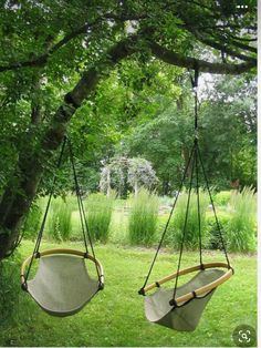 two hammocks hanging from trees in the grass