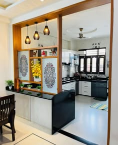an open kitchen and dining room area with white walls, black counter tops and wooden accents