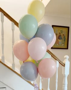 a bunch of balloons are hanging from the banister