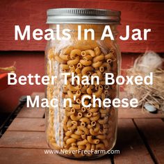 a jar filled with macaroni and cheese sitting on top of a wooden table