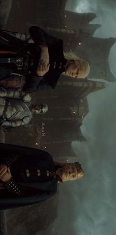 two people standing next to each other in front of a castle