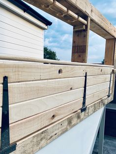 the side of a house that is made out of wood and has metal brackets on it