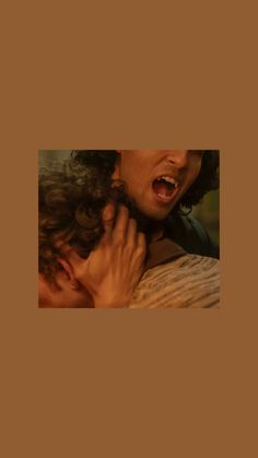 a woman holding onto another woman's shoulder while she has her face close to her chest