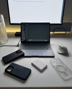 an open laptop computer sitting on top of a desk next to a mouse and cell phone