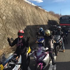 motorcyclists are lined up on the side of the road with their helmets on