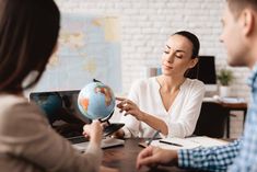 two people sitting at a table with a globe in front of them