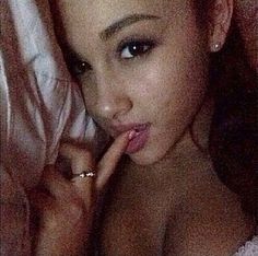 a close up of a woman with her finger on her lips