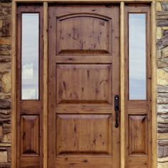 a close up of a wooden door on a stone building with two glass panes