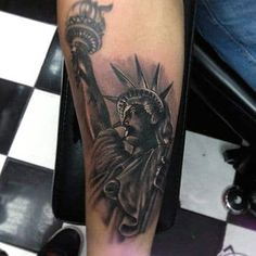 the statue of liberty tattoo on the arm is black and white, with grey ink
