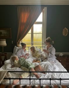 three women sitting on a bed with two children