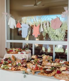 a table full of food with clothes hanging on the line in front of it,