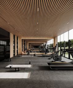there are many exercise machines in the gym area with large windows on both sides and floor to ceiling windows