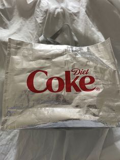 a diet coke bag sitting on top of a bed