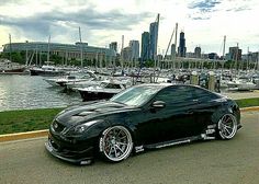 a black sports car parked in front of a marina