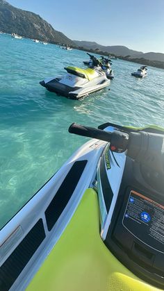 there are many jet skis in the water and one is on the side of the boat