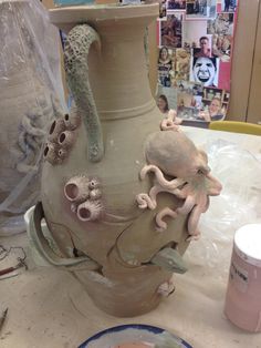 a clay vase with an octopus and sea creatures on it, sitting on a table