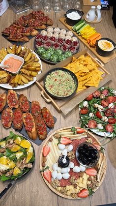 a table topped with lots of different types of food on plates and serving trays