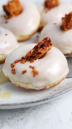 several glazed donuts on a plate with one bite taken out
