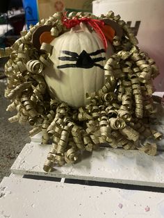 a pumpkin decorated like a lion head on top of a table