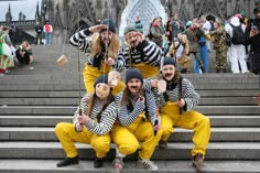 group of people dressed in yellow and black posing for the camera on some steps outside