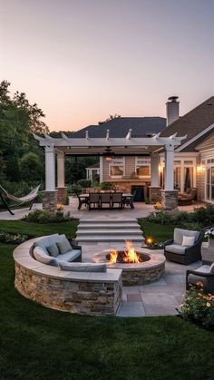 a fire pit in the middle of a yard with seating around it and an outdoor dining area