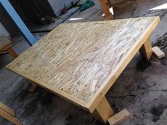 a wooden table sitting on top of a cement floor