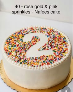 a white cake with sprinkles and a number 2 on it