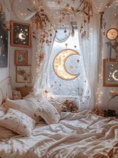 a white bed topped with lots of pillows under a window covered in stars and moon lights
