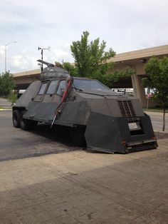 an armored vehicle is parked on the side of the road in front of a building