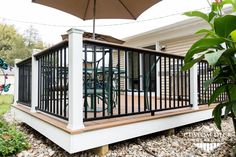 a deck with an umbrella over it in front of a house