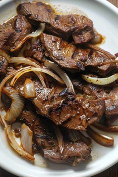 steak with onions and onions on a white plate