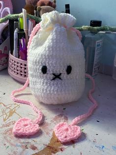 a crocheted bunny bag sitting on top of a table next to other items