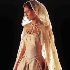 a woman in a wedding dress with a veil on her head and an apron over her shoulder