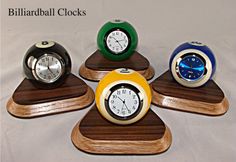 four clocks are arranged in the shape of flower petals on wooden bases, each with different colors and sizes
