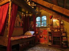 a bed sitting under a window next to a red curtained canopy in a bedroom